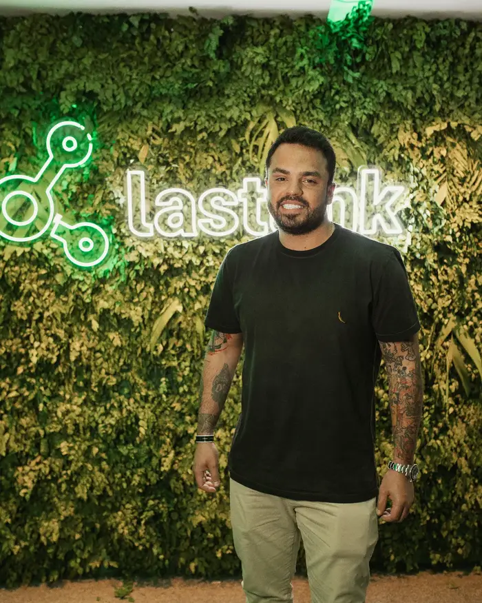 Jeff em frente ao letreiro da Lastlink, da qual é embaixador oficial